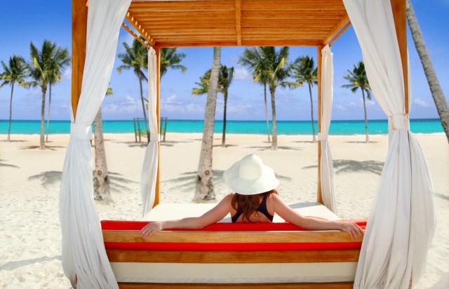 Woman on a beach sitting under a gazebo